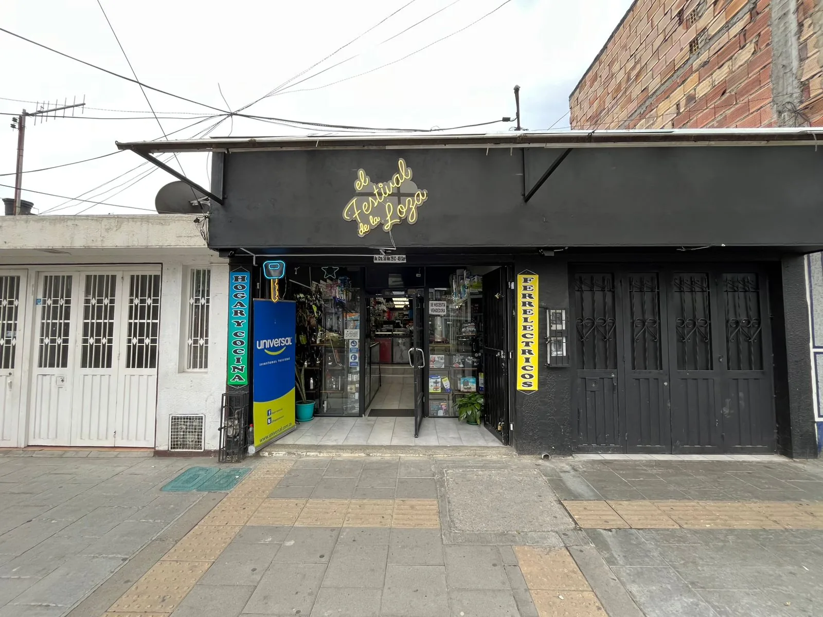 Fachada de El Festival de la Loza con su aviso de neón dorado sobre fondo negro